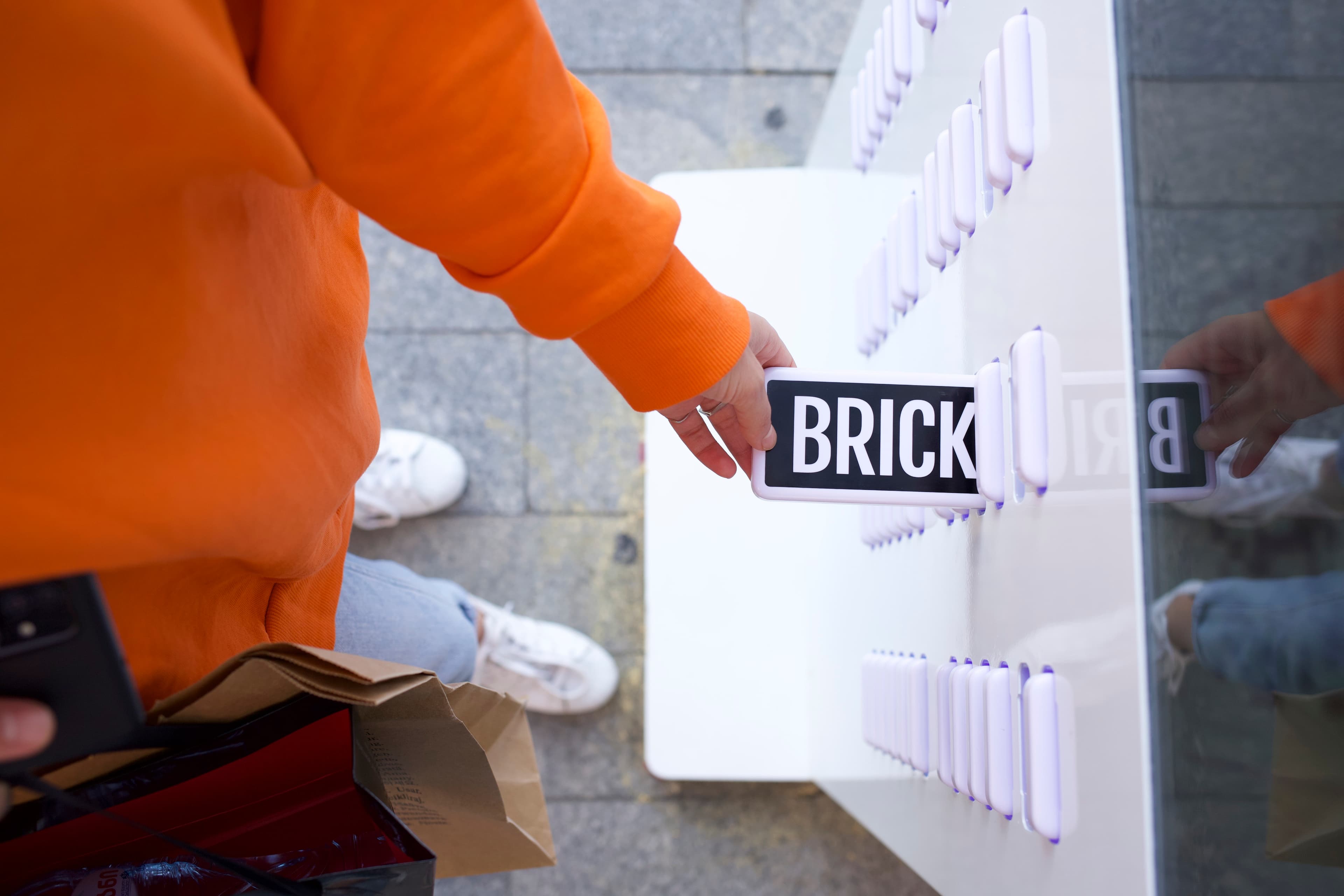 Una mano che recupera un power bank Brick da una postazione